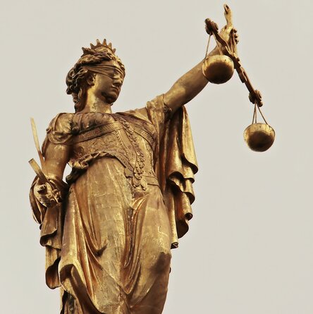 Statue der Justitia mit Schwert und Waage in den Händen